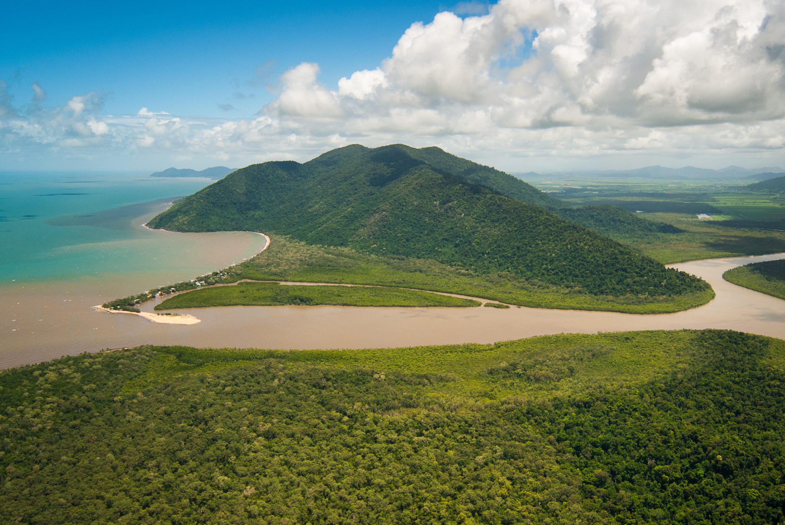 Aerial view of the sediment-laden Mulgrave-Russell River flowing from an agricultural landscape into coastal waters.