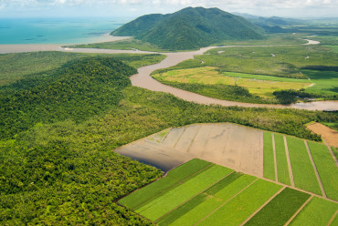 Aerial view of the sediment-laden Mulgrave-Russell River flowing from an agricultural landscape into coastal waters.